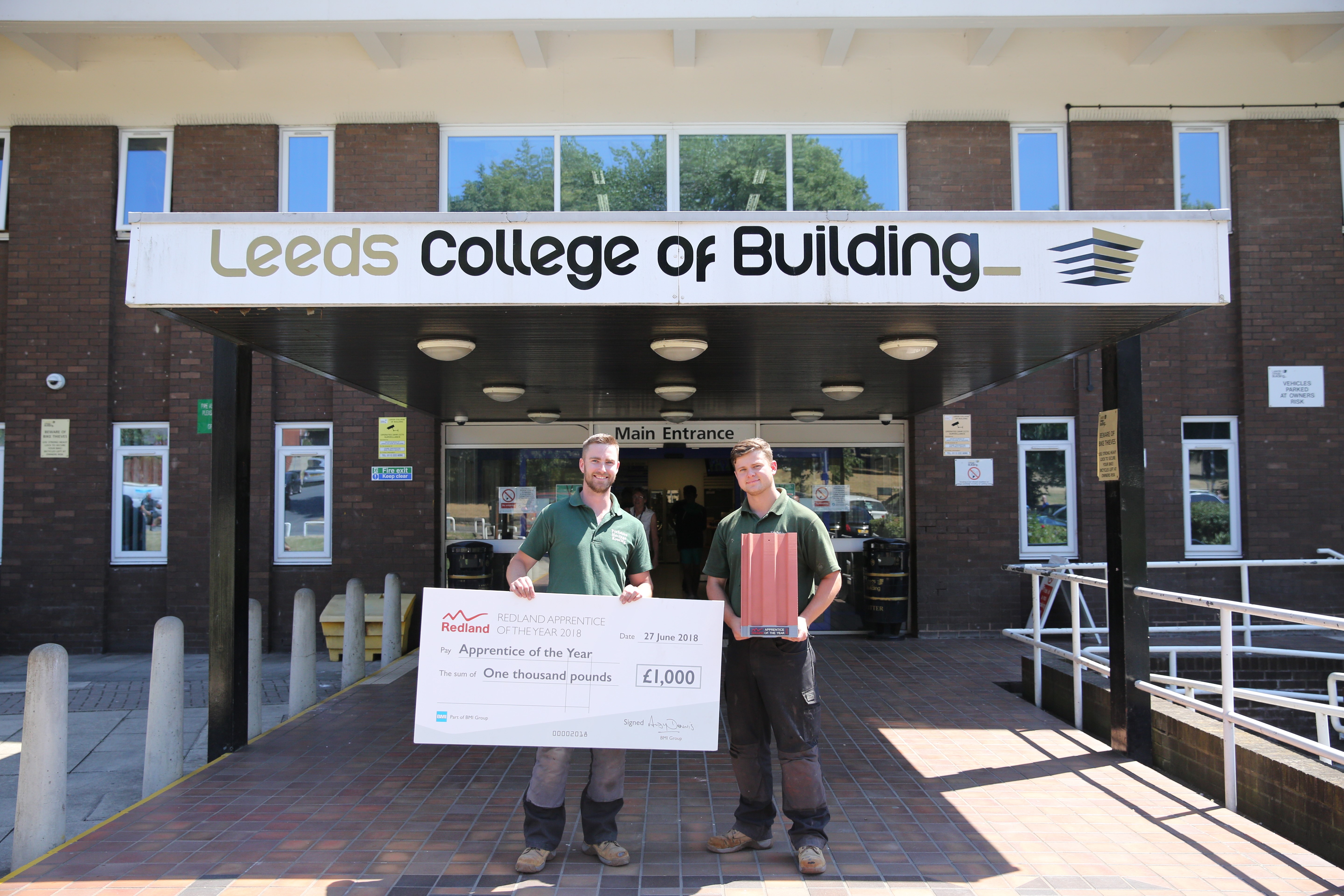 Jay Webster (right) with his prize cheque outside the Leeds College of Building North Street Campus.
