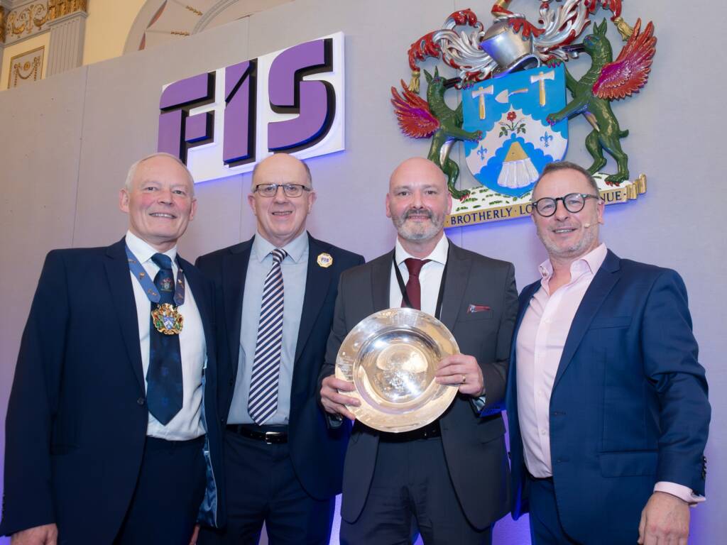 Image of Wayne Chappelow, receiving the lifetime achievement award, standing along side the president and other members of the FIS.