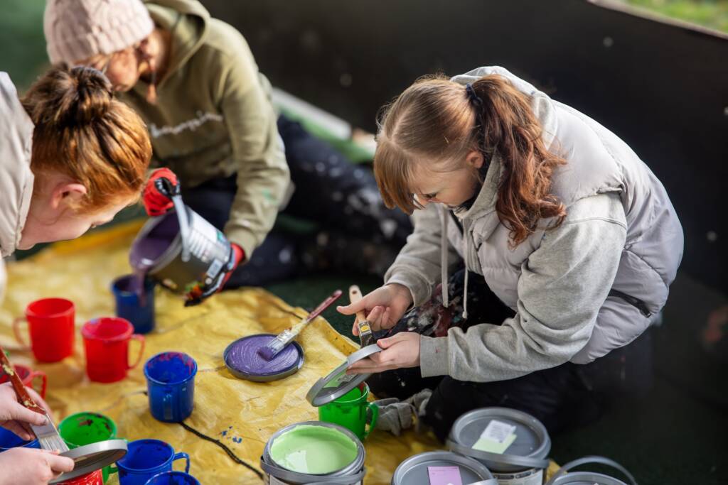 This is a photo of LCB students preparing paints for use on the mural.