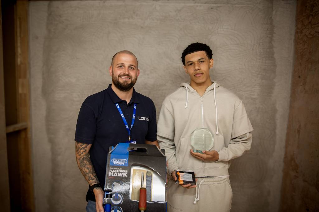 Image of Reece Williams holding his award next to his tutor Liam Addinall holding a trowel gift set