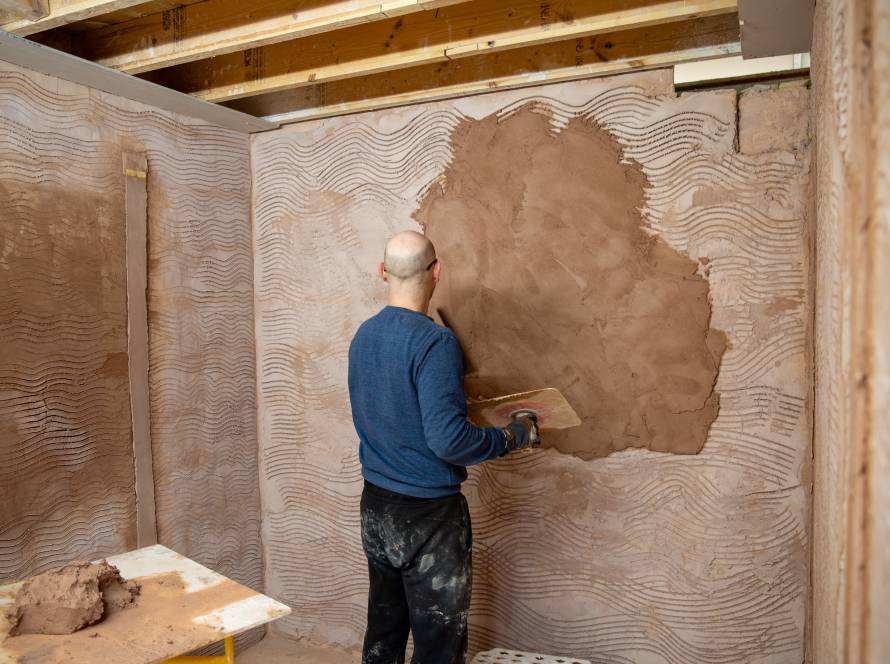 Apprentice plastering in workshop as part of Mark Speight's EWI bootcamp.