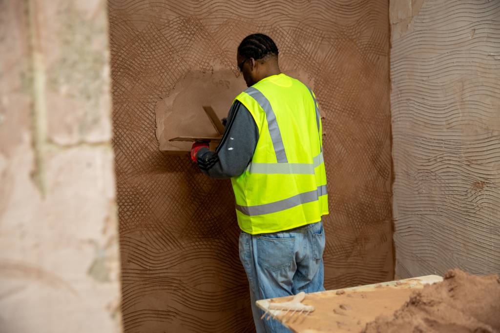 Apprentice plastering in workshop as part of Mark Speight's EWI bootcamp.