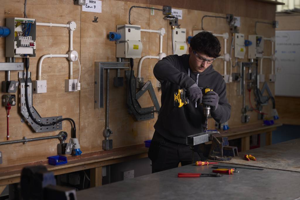 LCB student using electric screwdriver in workshop.