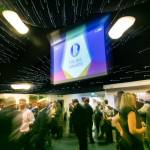 This photo depicts guests socialising as well as one of the events large digital presentation screens.