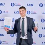 This photo depicts a student with their award against the LCBU photo wall.