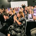 This photo depicts multiple guests at the awards sitting at their tables.