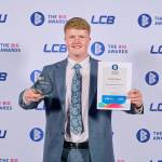 This photo depicts a student with their award against the LCBU photo wall.