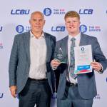 This photo depicts a student with their award against the LCBU photo wall.