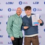 This photo depicts a student with their award against the LCBU photo wall.
