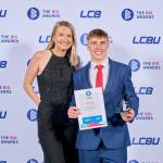 This photo depicts a student with their award against the LCBU photo wall.