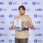 This photo depicts a student with their award against the LCBU photo wall.