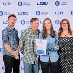 This photo depicts a student with their award against the LCBU photo wall.
