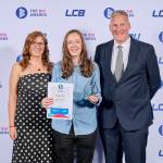 This photo depicts a student with their award against the LCBU photo wall.