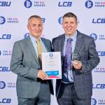 This photo depicts a student with their award against the LCBU photo wall.