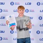 This photo depicts a student with their award against the LCBU photo wall.