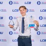 This photo depicts a student with their award against the LCBU photo wall.