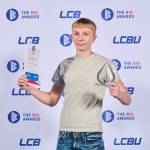 This photo depicts a student with their award against the LCBU photo wall.