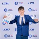 This photo depicts a student with their award against the LCBU photo wall.