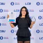 This photo depicts a student with their award against the LCBU photo wall.