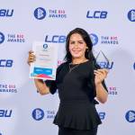 This photo depicts a student with their award against the LCBU photo wall.