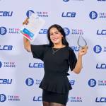 This photo depicts a student with their award against the LCBU photo wall.