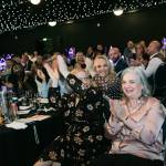 This photo depicts multiple guests at the event sitting at their tables.