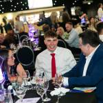 This photo depicts multiple guests at the awards sitting at their tables.