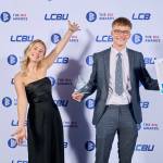 This photo depicts a student with their award against the LCBU photo wall.