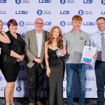 This photo depicts a student with their award against the LCBU photo wall.