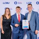 This photo depicts a student with their award against the LCBU photo wall.
