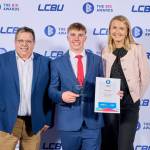 This photo depicts a student with their award against the LCBU photo wall.