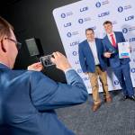 This photo depicts a student with their award against the LCBU photo wall.