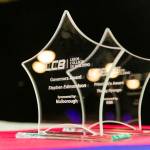 The photo features the trophies of the governors award and principles award, they are being presented on a table on the main stage of the award venue.