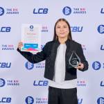 This photo depicts a student with their award against the LCBU photo wall.