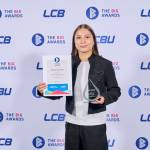 This photo depicts a student with their award against the LCBU photo wall.
