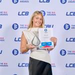 This photo depicts a student with their award against the LCBU photo wall.