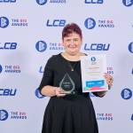 This photo depicts a student with their award against the LCBU photo wall.