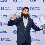 This photo depicts a student with their award against the LCBU photo wall.