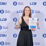 This photo depicts a student with their award against the LCBU photo wall.