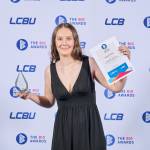 This photo depicts a student with their award against the LCBU photo wall.