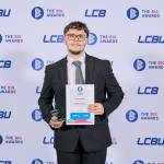 This photo depicts a student with their award against the LCBU photo wall.