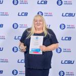 This photo depicts a student with their award against the LCBU photo wall.