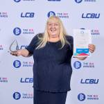 This photo depicts a student with their award against the LCBU photo wall.