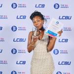 This photo depicts a student with their award against the LCBU photo wall.