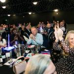 This photo depicts multiple guests at the awards sitting at their tables.
