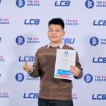 This photo depicts a student with their award against the LCBU photo wall.