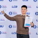 This photo depicts a student with their award against the LCBU photo wall.