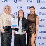 This photo depicts a student with their award against the LCBU photo wall.