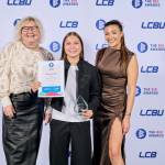This photo depicts a student with their award against the LCBU photo wall.