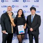 This photo depicts a student with their award against the LCBU photo wall.